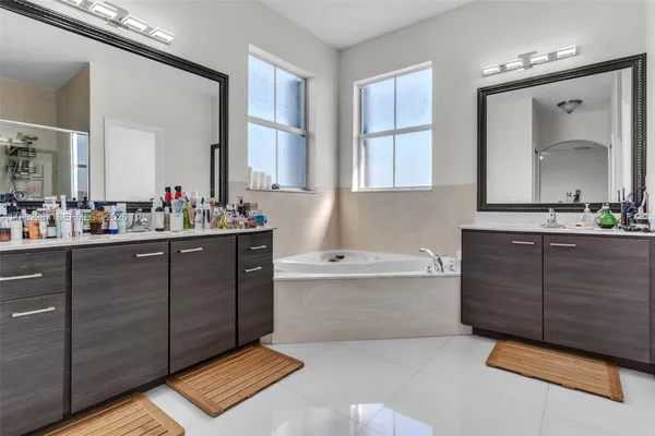 a bathroom with a tub sink and mirror