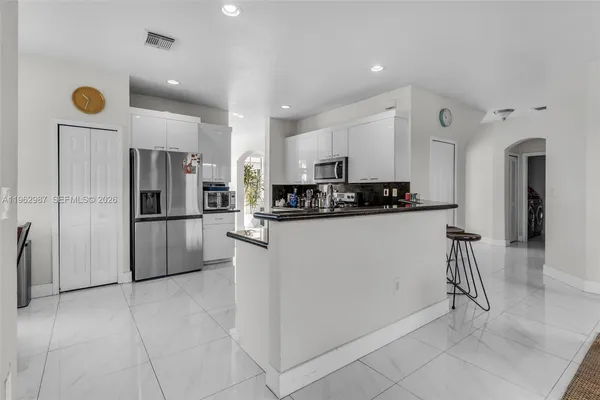a kitchen with stainless steel appliances granite countertop a refrigerator and a stove top oven