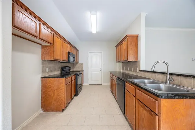 a kitchen with stainless steel appliances granite countertop a sink a stove and a refrigerator