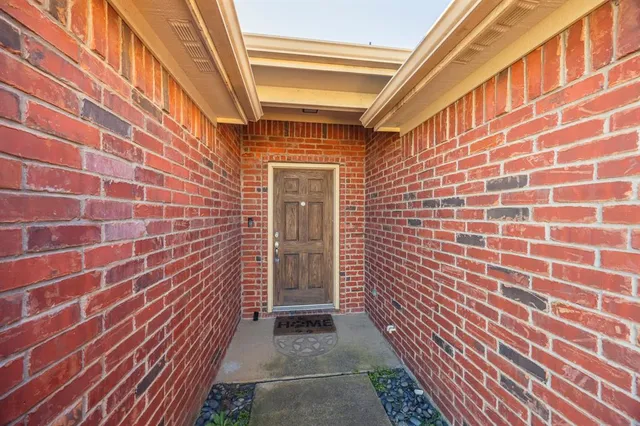 a view of a brick wall with wooden floor and a building