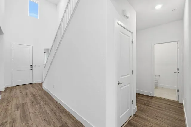 a view of a hallway with wooden floor and a ceiling fan