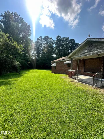 a backyard of a house with table and chairs