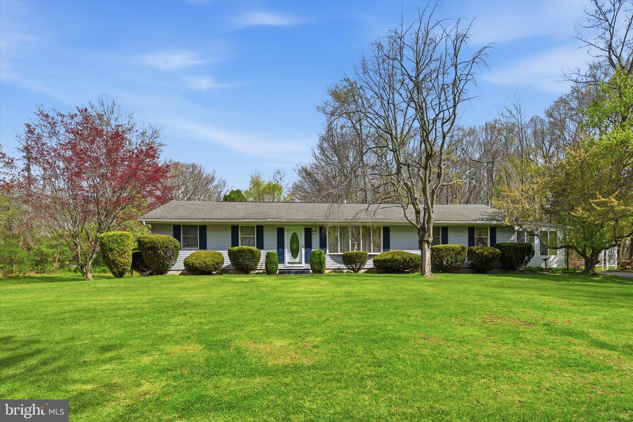 a view of a house with a big yard and large trees