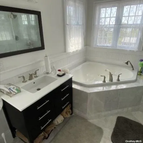 a bathroom with a sink mirror and a bathtub
