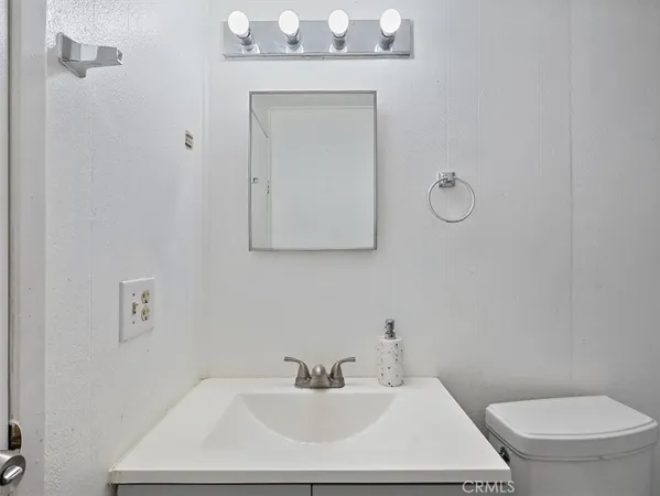 a bathroom with a sink a toilet and mirror