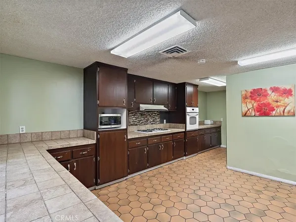 a kitchen with stainless steel appliances granite countertop a refrigerator and a stove top oven