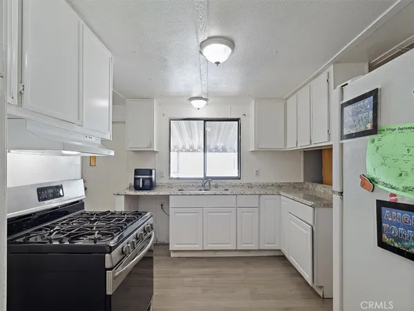 a kitchen with cabinets appliances a sink and a window