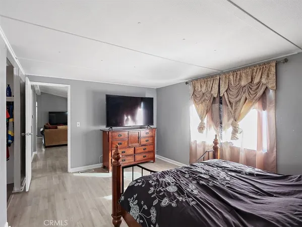 a bedroom with a bed and a flat tv screen on wall
