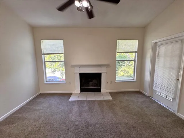 an empty room with a fireplace and window