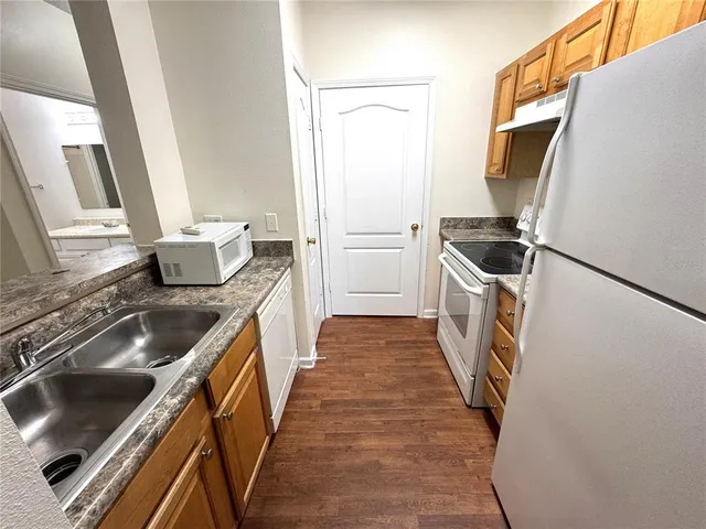 a kitchen with sink stove and refrigerator