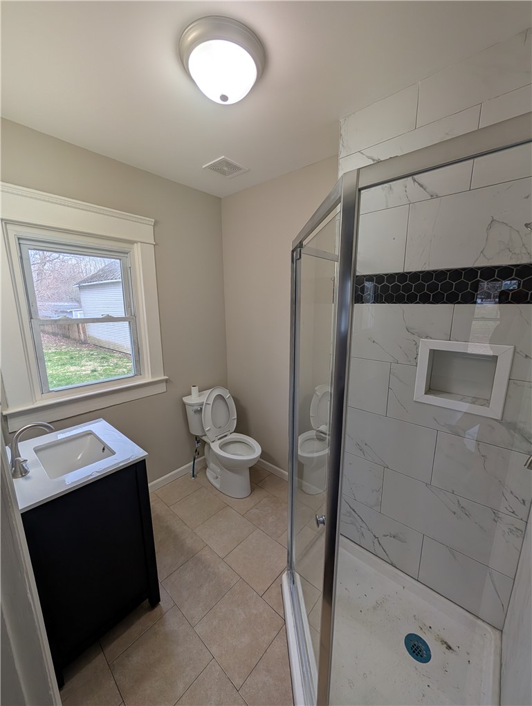 10796 Preble County Line Road Brookville, OH 45309 - Photo 12 of 33 This bright bathroom features a modern vanity, a glass-enclosed shower, and ample natural light.