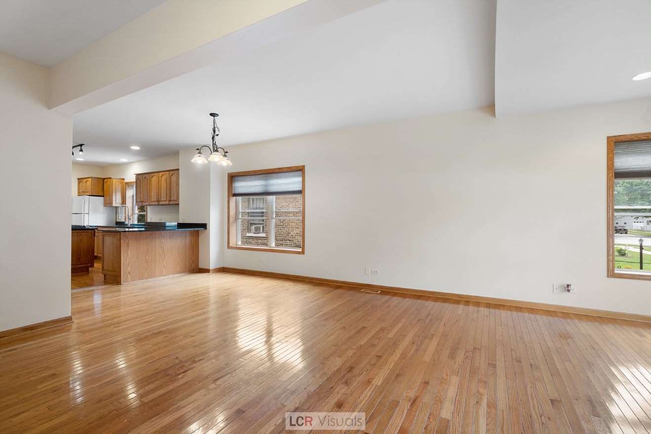 7112 West Belden Avenue Chicago, IL 60707 - Photo 3 of 19 a view of an empty room with wooden floor and kitchen view