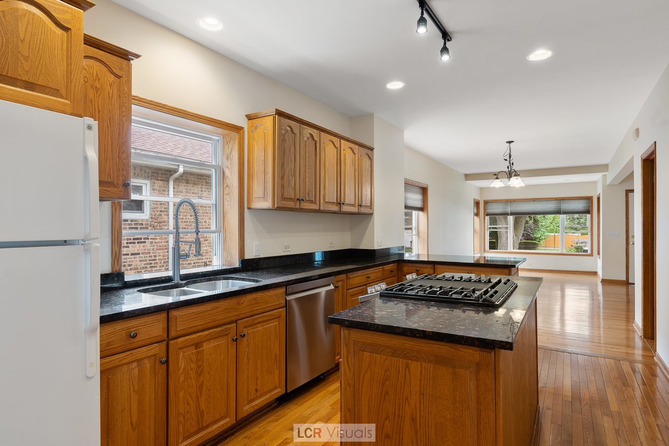7112 West Belden Avenue Chicago, IL 60707 - Photo 5 of 19 a kitchen with granite countertop a sink stove and cabinets