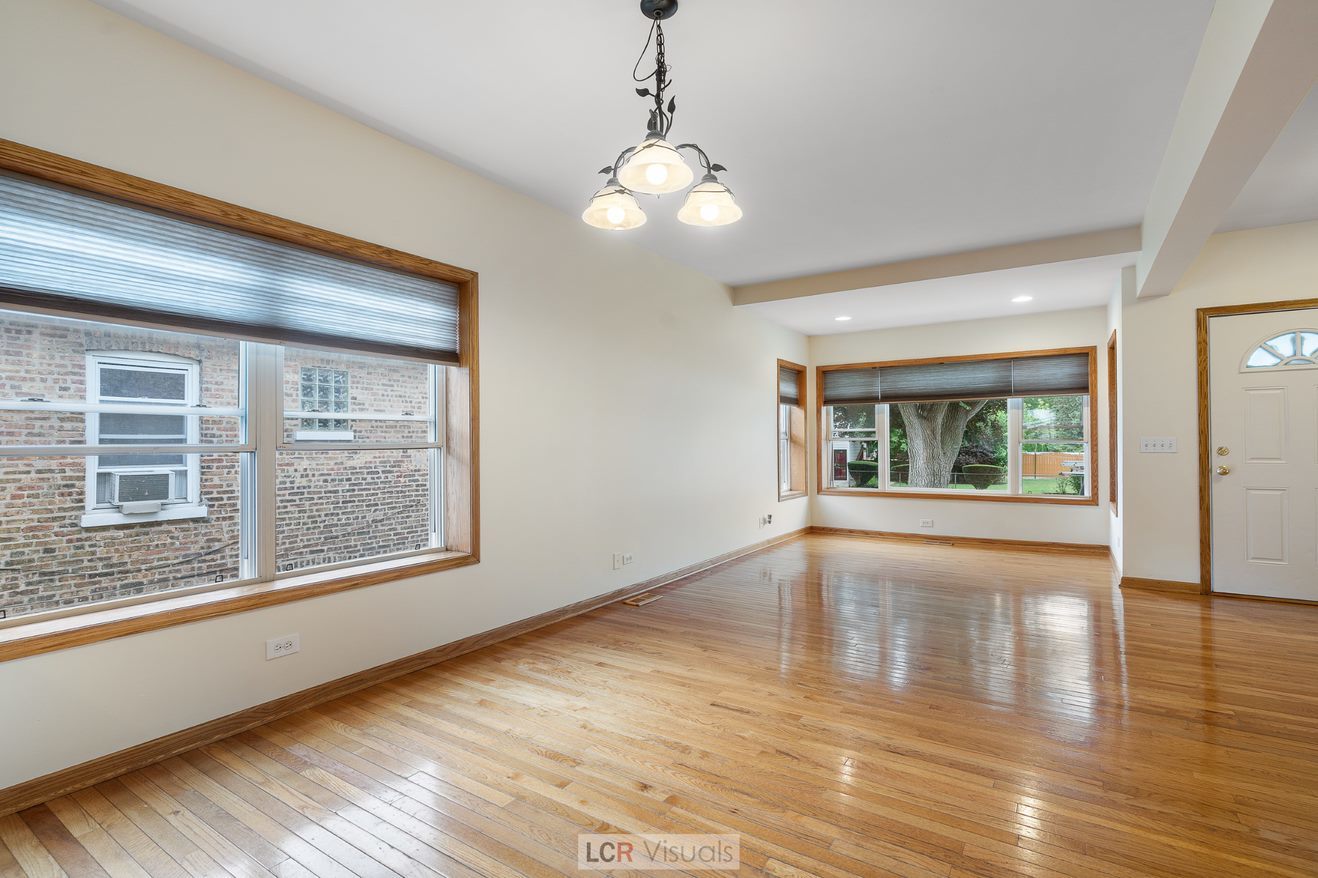 7112 West Belden Avenue Chicago, IL 60707 - Photo 7 of 19 a view of an empty room with wooden floor and a window
