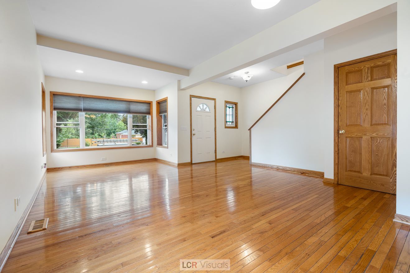 7112 West Belden Avenue Chicago, IL 60707 - Photo 8 of 19 a view of an empty room with wooden floor and a window