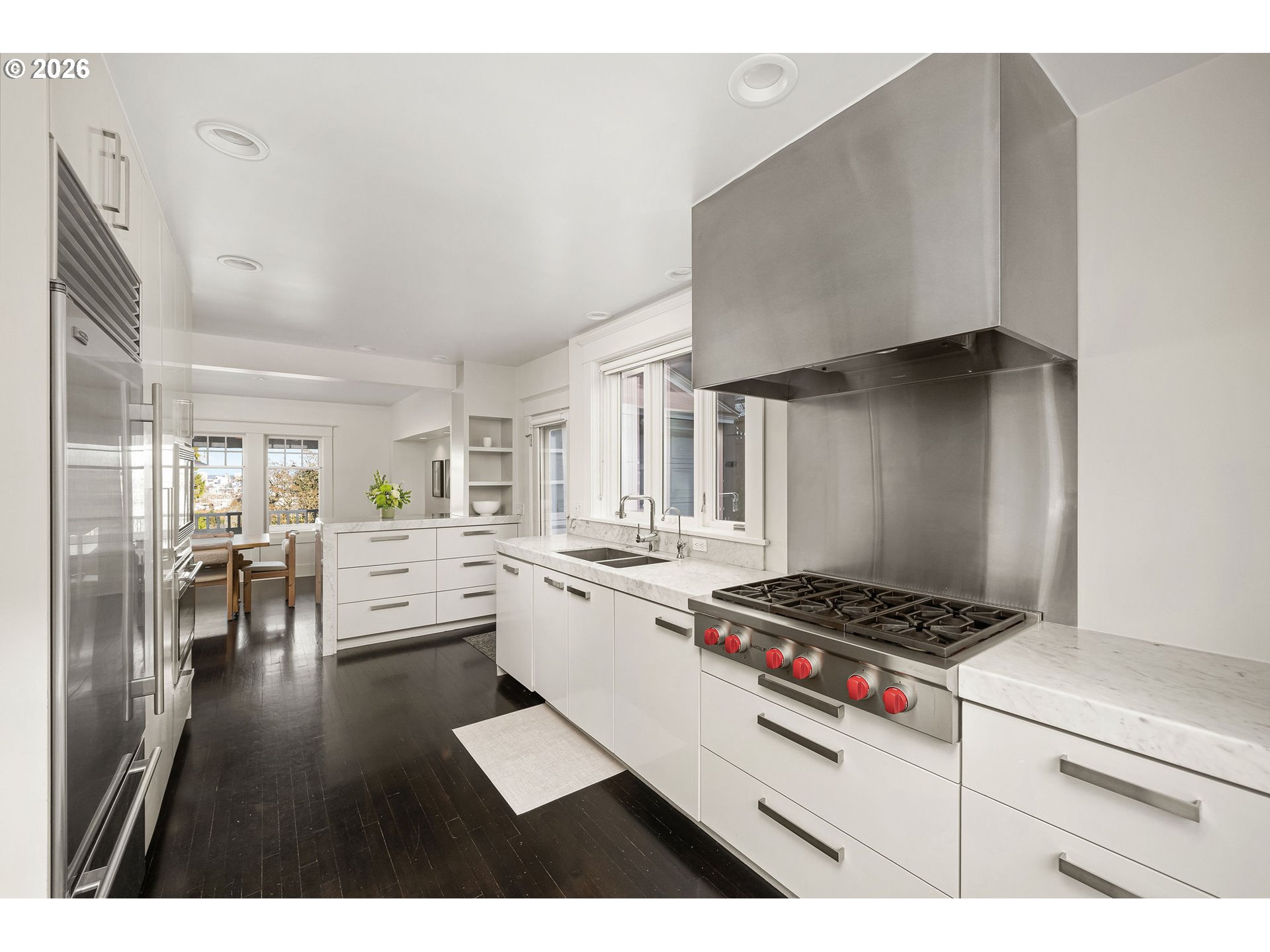 840 Northwest Summit Avenue Portland, OR 97210 - Photo 9 of 48 a kitchen with granite countertop a stove a sink dishwasher and a dining table with wooden floor