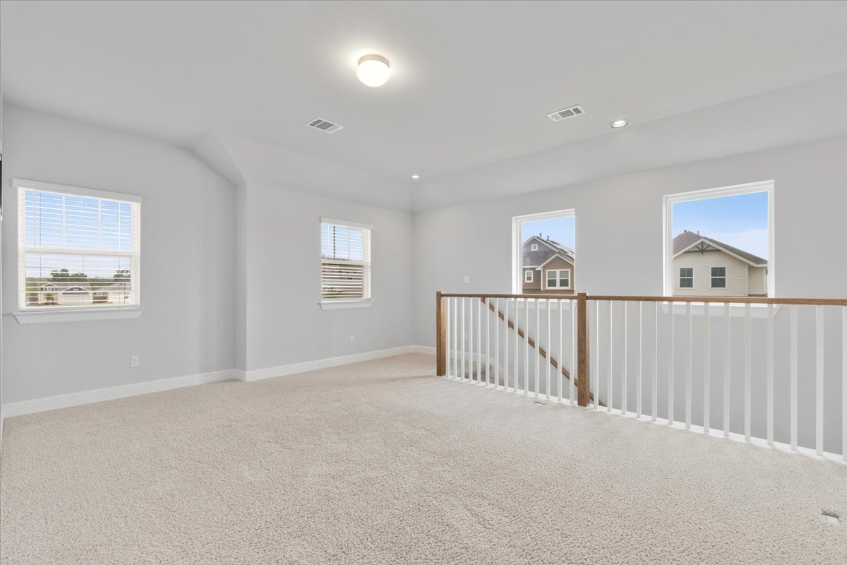 101 Free Stone Drive Georgetown, TX 78628 - Photo 20 of 40 Spacious second-level landing with plush carpet flooring, white baluster railing, and a wood-finish handrail
