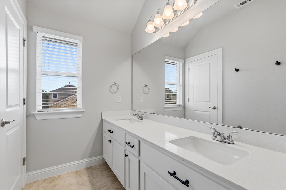 101 Free Stone Drive Georgetown, TX 78628 - Photo 27 of 40 Dual sink vanity with white cabinetry and dark hardware
