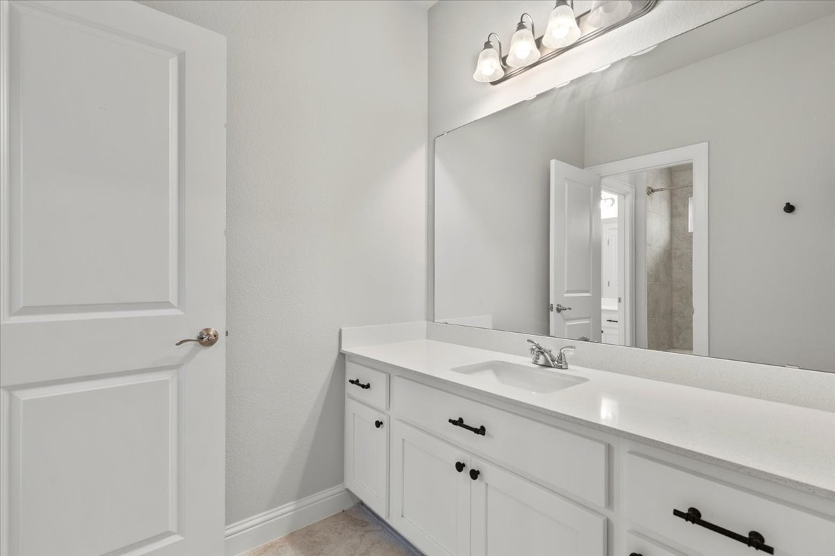 101 Free Stone Drive Georgetown, TX 78628 - Photo 29 of 40 Bathroom featuring an extended single vanity with white cabinetry, a large integrated mirror, and brushed nickel hardware