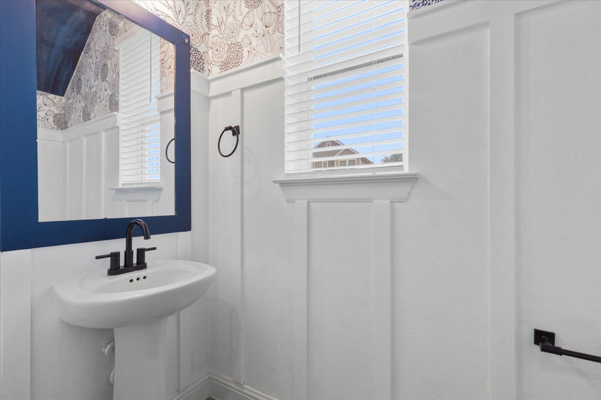 101 Free Stone Drive Georgetown, TX 78628 - Photo 31 of 40 Pedestal sink with a matte black faucet, framed mirror, and board and batten wainscoting