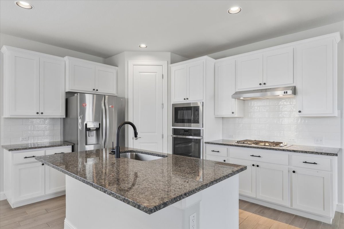 101 Free Stone Drive Georgetown, TX 78628 - Photo 5 of 40 Kitchen featuring an expansive island with a granite countertop and integrated sink