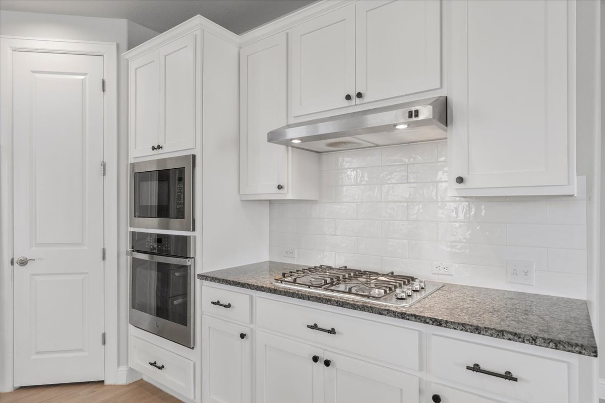 101 Free Stone Drive Georgetown, TX 78628 - Photo 6 of 40 White shaker cabinetry, stainless steel appliances, a gas cooktop, and a subway tile backsplash define this kitchen space