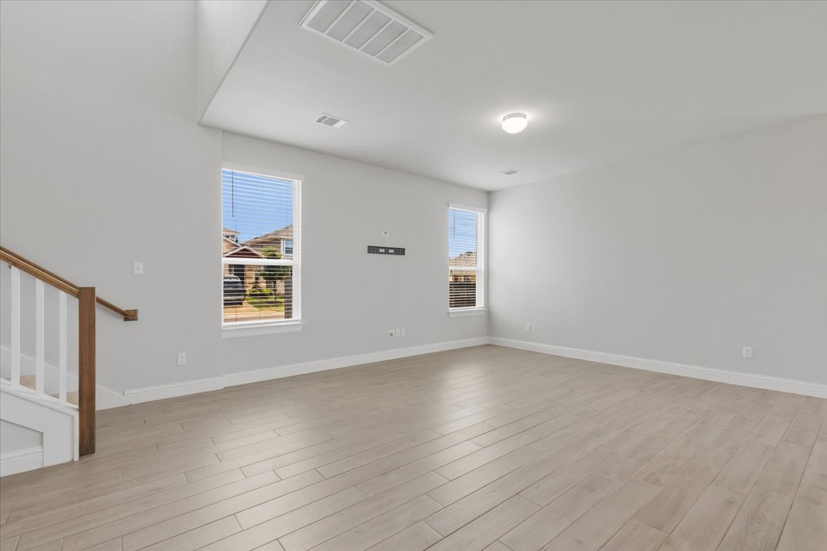 101 Free Stone Drive Georgetown, TX 78628 - Photo 8 of 40 Spacious living area featuring wood-finish flooring, light gray walls, white baseboards, and multiple windows with blinds