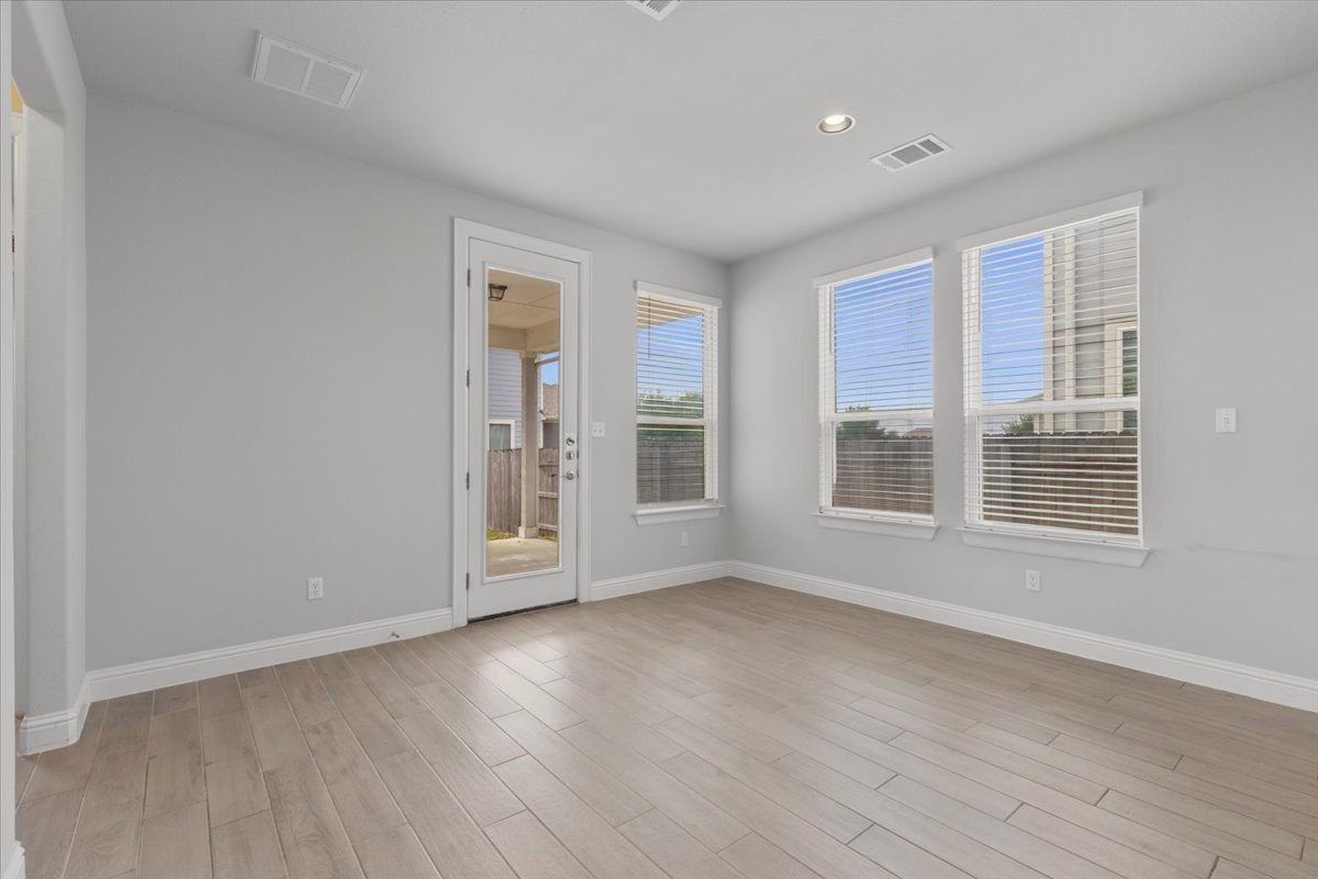 101 Free Stone Drive Georgetown, TX 78628 - Photo 10 of 40 Spacious room featuring wood-finish flooring, light grey walls, white trim, and multiple windows with blinds