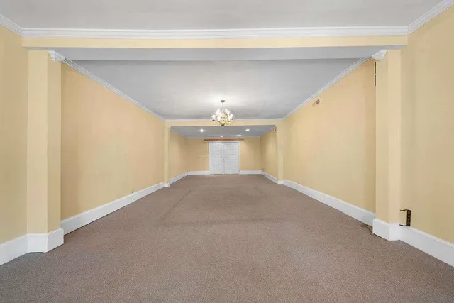a view of a big room with windows and chandelier fan