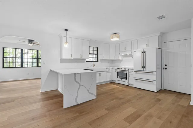 a kitchen with white cabinets and stainless steel appliances