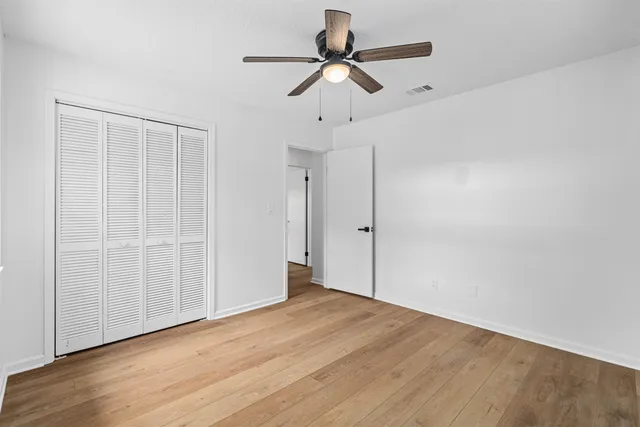 a view of empty room with wooden floor