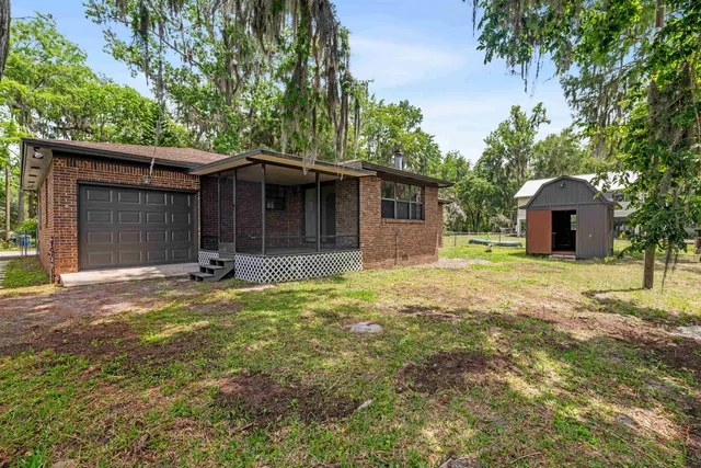 a view of a house with backyard and trees