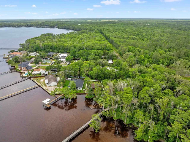 an aerial view of a houses with a yard and lake view