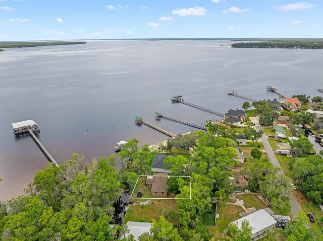 an aerial view of a house with a lake and outdoor space