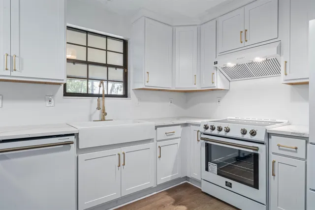 a kitchen with white cabinets and white stove