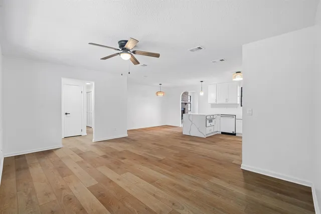a view of a kitchen with wooden floor and a ceiling fan