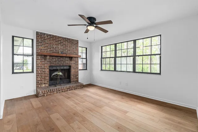wooden floor fireplace and windows in an empty room