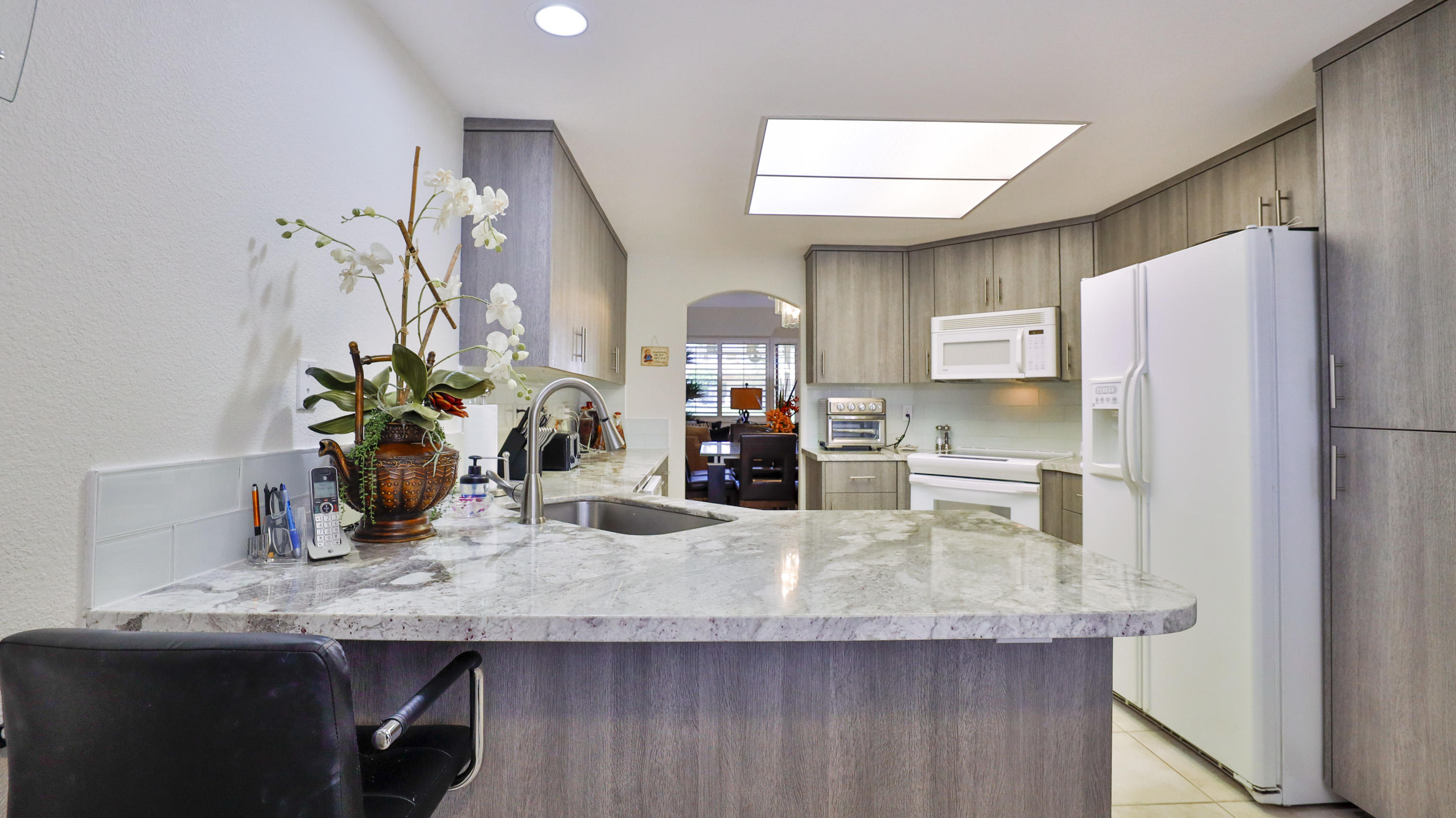 42641 Liolios Drive Palm Desert, CA 92211 - Photo 14 of 44 a kitchen with granite countertop a counter space cabinets and stainless steel appliances