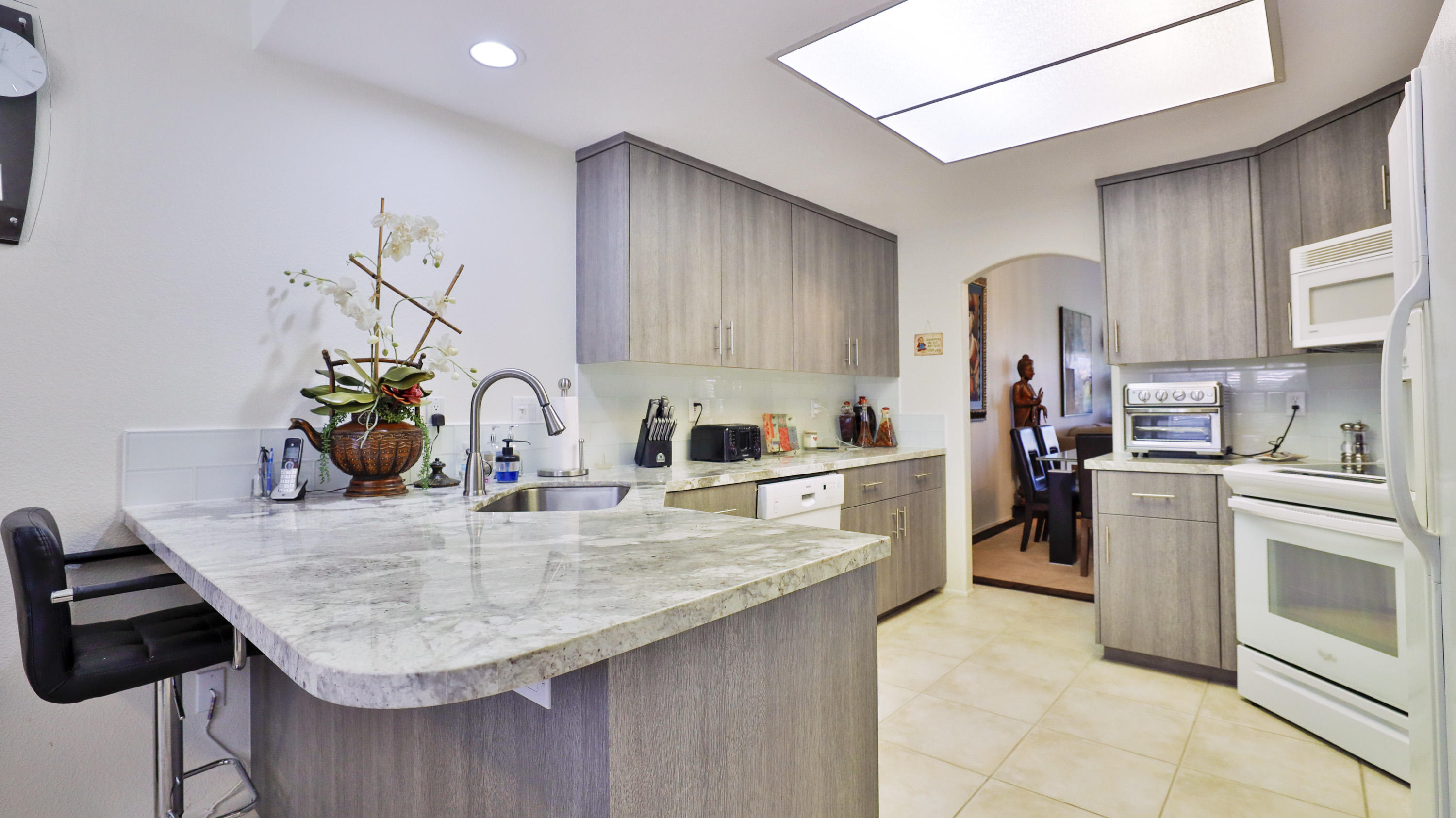 42641 Liolios Drive Palm Desert, CA 92211 - Photo 15 of 44 a kitchen with kitchen island granite countertop a sink cabinets and stainless steel appliances