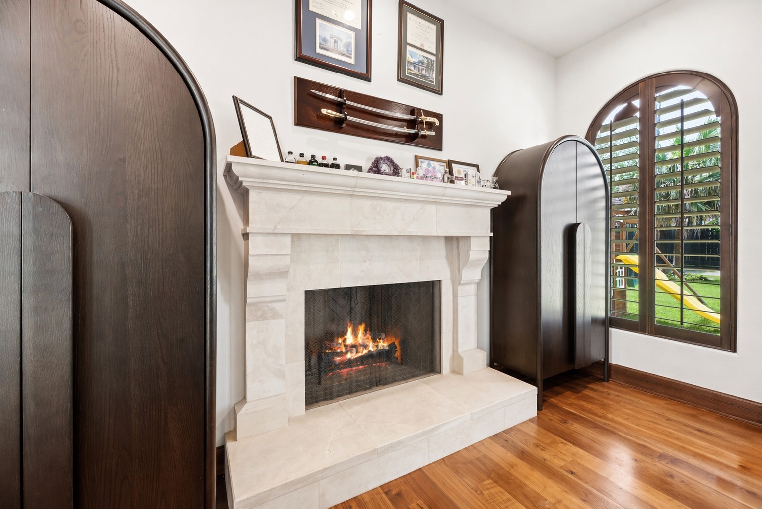 3803 Drake Street Houston, TX 77005 - Photo 7 of 32 A second gas-log fireplace with a custom stone mantel anchors the study, adding warmth and a sophisticated focal point to this versatile workspace.