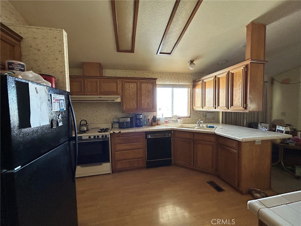 27250 Murrieta Road, Unit 347 Menifee, CA 92586 - Photo 10 of 39 a kitchen with stainless steel appliances granite countertop a sink stove and refrigerator