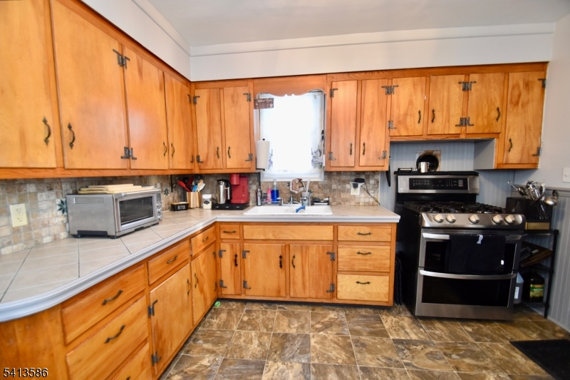 406 Morsetown Road West Milford, NJ 07480 - Photo 10 of 17 a large kitchen with stainless steel appliances granite countertop a stove a sink and a microwave