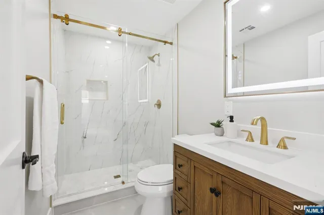 a bathroom with a sink a toilet and shower