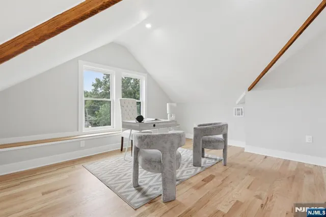 a living room with furniture a large window and wooden floor