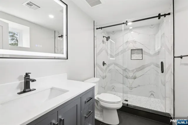 a bathroom with a sink a toilet and shower