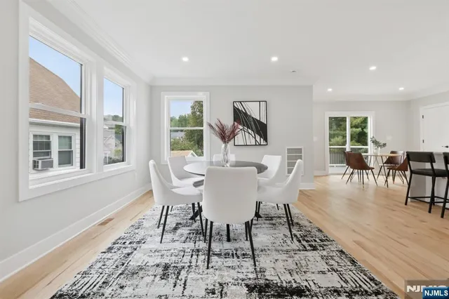 a dining room with furniture wooden floor a rug and a painting