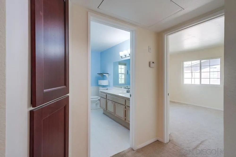 17161 Alva Road, Unit 2323 San Diego, CA 92127 - Photo 14 of 23 a view of a hallway with wooden floor and a living room