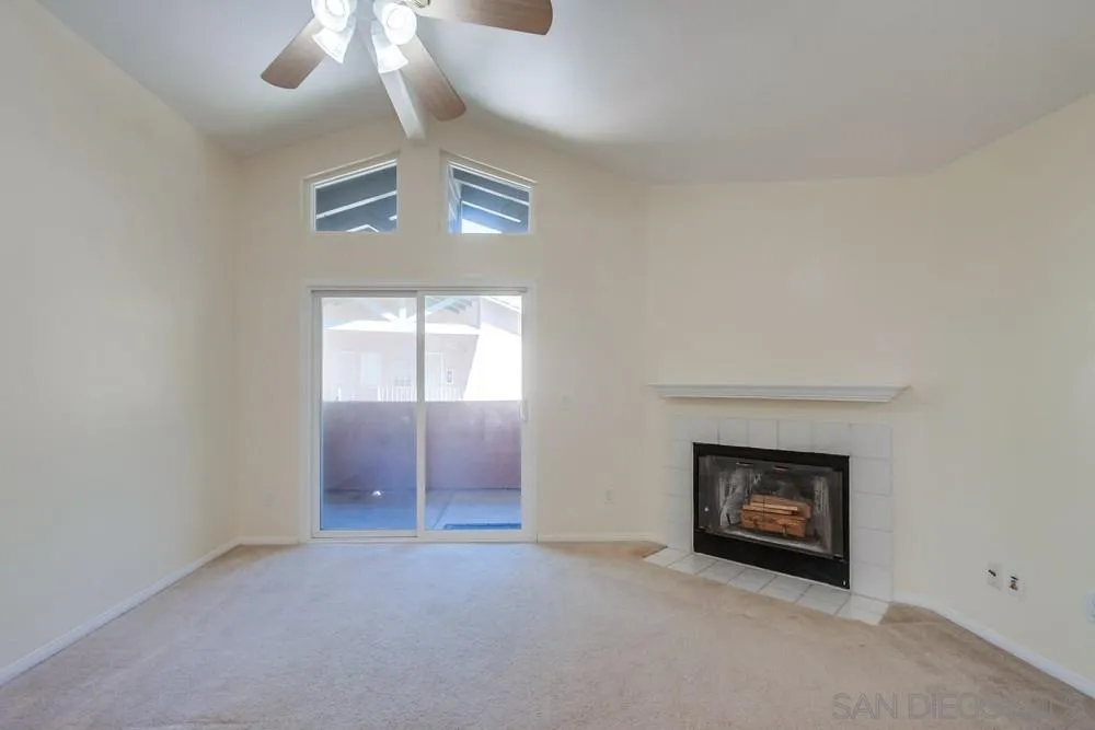 17161 Alva Road, Unit 2323 San Diego, CA 92127 - Photo 5 of 23 an empty room with a fireplace and chandelier fan