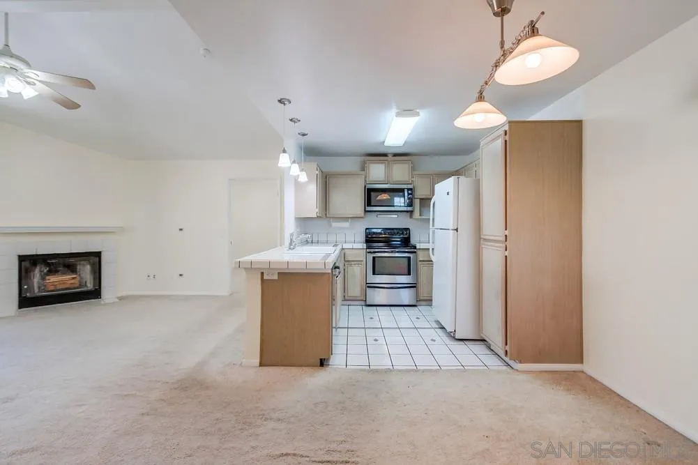 17161 Alva Road, Unit 2323 San Diego, CA 92127 - Photo 7 of 23 a kitchen with refrigerator and microwave