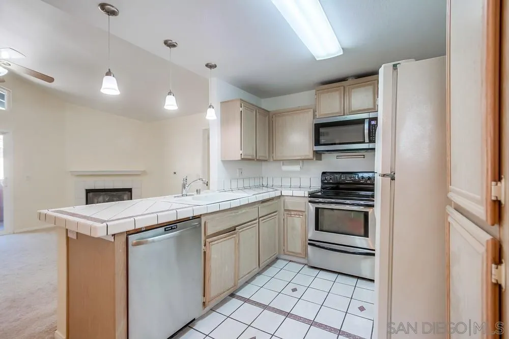 17161 Alva Road, Unit 2323 San Diego, CA 92127 - Photo 8 of 23 a kitchen with a sink stove top oven and cabinets
